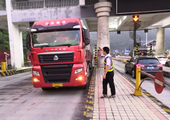 圖為收費(fèi)班長(zhǎng)引導(dǎo)該車(chē)駛出收費(fèi)站